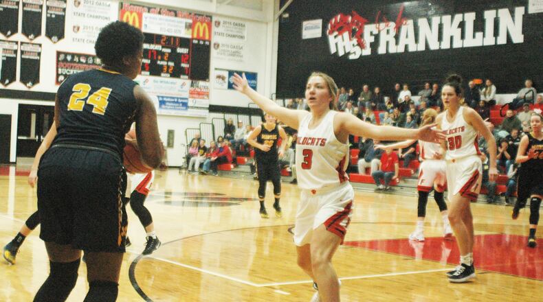 Franklin's Kaylee Harris (3) and Layne Ferrell (30) are on defense as Monroe's Olivia Wells-Daniels (24) prepares to launch a 3-pointer during Saturday afternoon's game at Darrell Hedric Gym in Franklin. The host Wildcats won 52-34. RICK CASSANO/STAFF