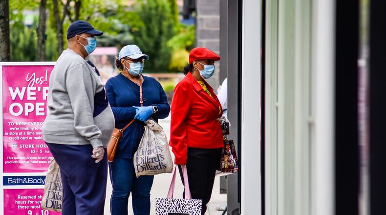 Joey Shields, left, Shelley Gates, middle, and Josephine Gates wear masks as they shop at Liberty Center in Liberty Township on the first day most retail stores were allowed to open Tuesday, May 12, 2020. Most non-essential retail stores have been closed to the public since the stay-at-home order went into place due to the coronavirus pandemic. NICK GRAHAM / STAFF