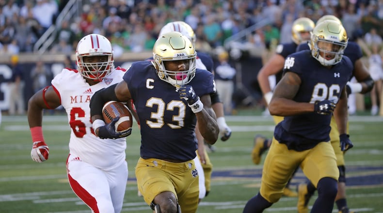 Notre Dame running back Josh Adams (33) heads for the end zone in front of Miami’s A.J. Burdine during Saturday night’s 52-17 Fighting Irish victory at Notre Dame Stadium in Notre Dame, Ind. CHARLES REX ARBOGAST/ASSOCIATED PRESS