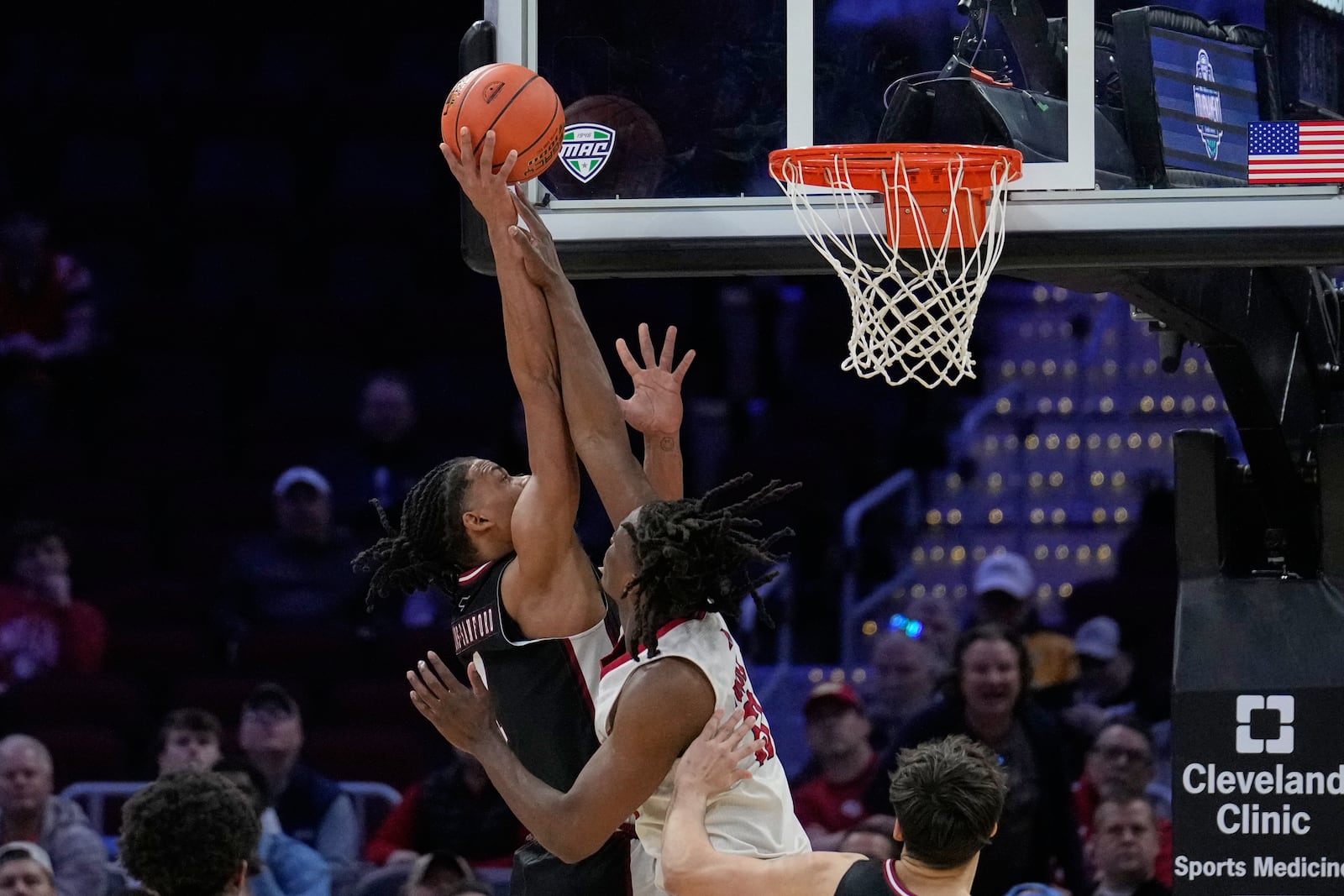 Massachusetts forward Daniel Hankins-Sanford (1) shoots as Miami (Ohio) forward Antwone Woolfolk (13) defends in the second half of a basketball game in the quarterfinals of the Mid-American Conference tournament, Thursday, March 12, 2026, in Cleveland. (AP Photo/Sue Ogrocki)