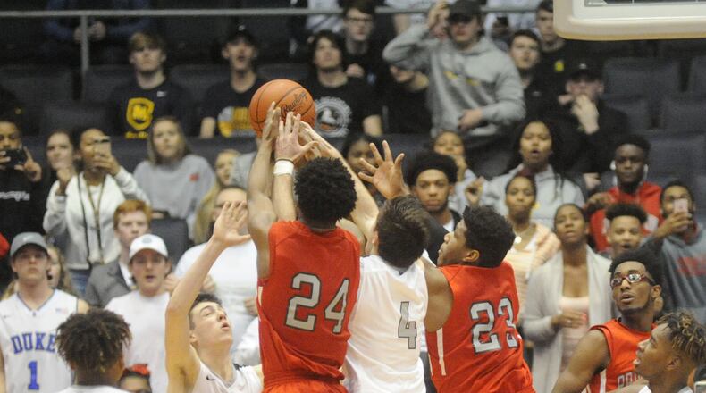 Lakota East’s Jalen Peck (44), Bash Wieland (22), Jackson See (4) and Jarrett Cox (right) battle Princeton’s Darweshi Hunter (24) and Gabe O’Neal (23) for a final rebound in the closing seconds of Saturday’s Division I district final at the University of Dayton Arena. Hunter got the rebound, was fouled and hit two free throws to give the Vikings a 53-51 victory. MARC PENDLETON/STAFF