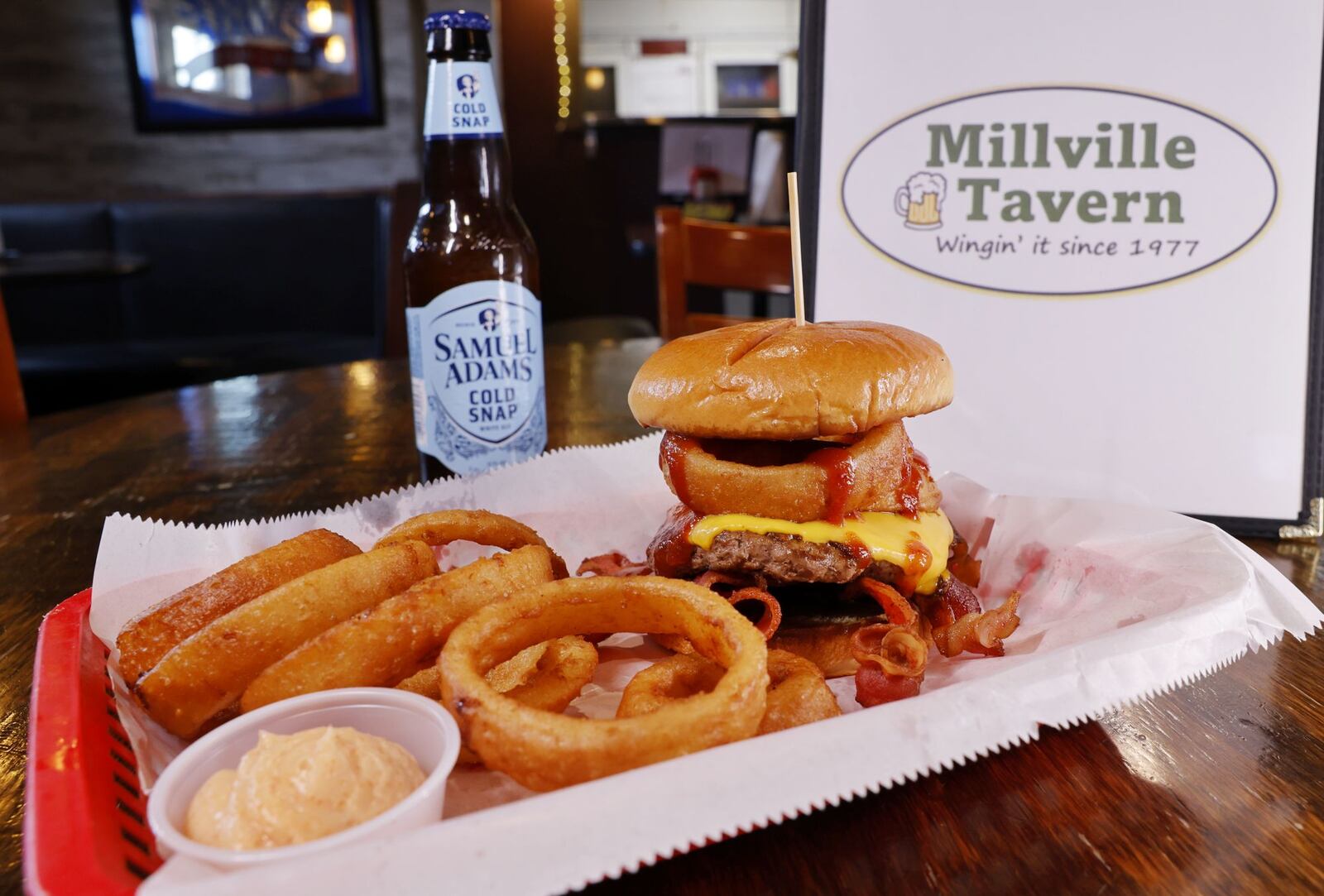 Millville Tavern is open with daily lunch specials, Thursday wing day, live music, darts and more. This is their stagecoach burger with onion rings. NICK GRAHAM/STAFF