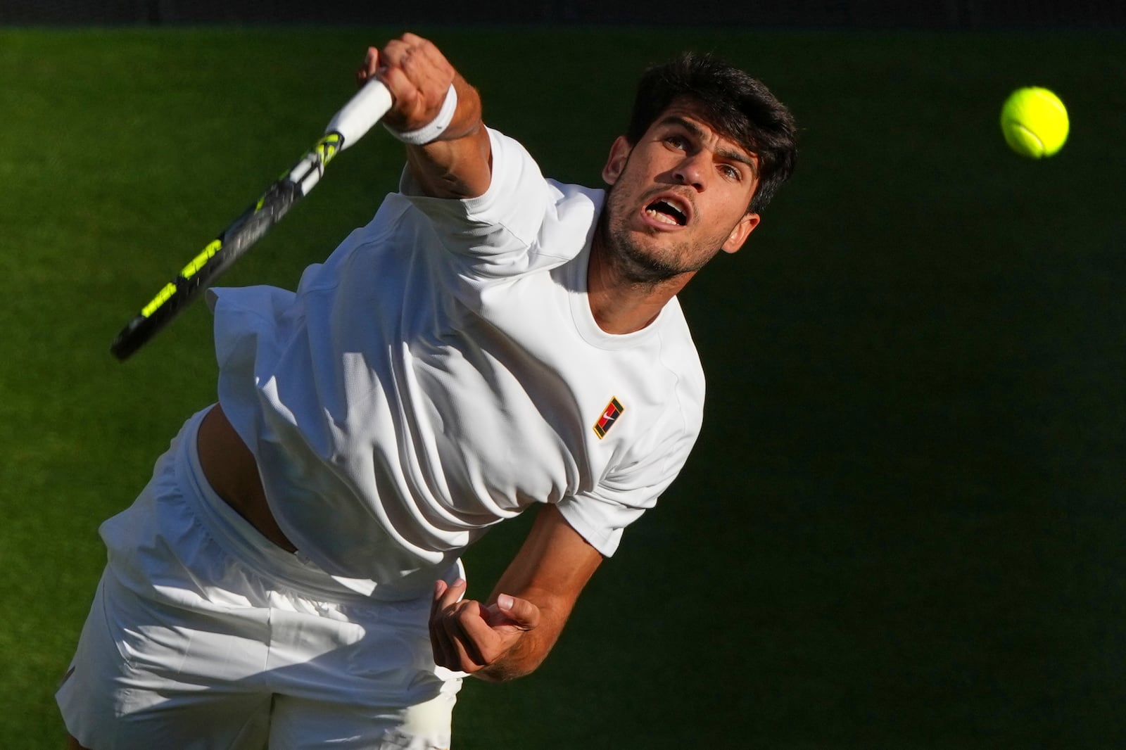 Spain's Carlos Alcaraz serves to Britain's Cameron Norrie during a quarterfinal men's singles match at the Wimbledon Tennis Championships in London, Tuesday, July 8, 2025. (AP Photo/Joanna Chan)