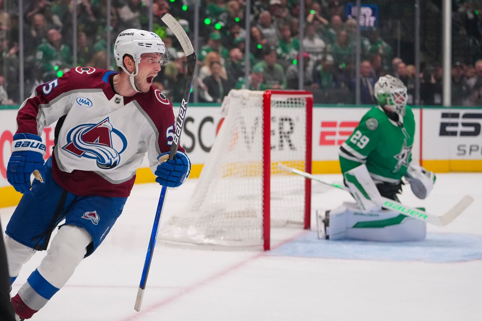 Colorado Avalanche defenseman Ryan Lindgren, left, reacts after shot by teammate center Jack Drury, not visible, entered the net of Dallas Stars goaltender Jake Oettinger, right, for a goal during the second period in Game 2 of a first-round NHL hockey playoff series Monday, April 21, 2025, in Dallas. (AP Photo/Julio Cortez)