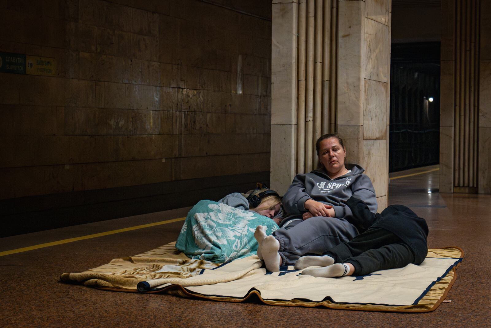 People rest in a metro station, being used as a bomb shelter, during a Russian drones attack in Kyiv, Ukraine, early Friday, June 6, 2025. (AP Photo/Dan Bashakov)