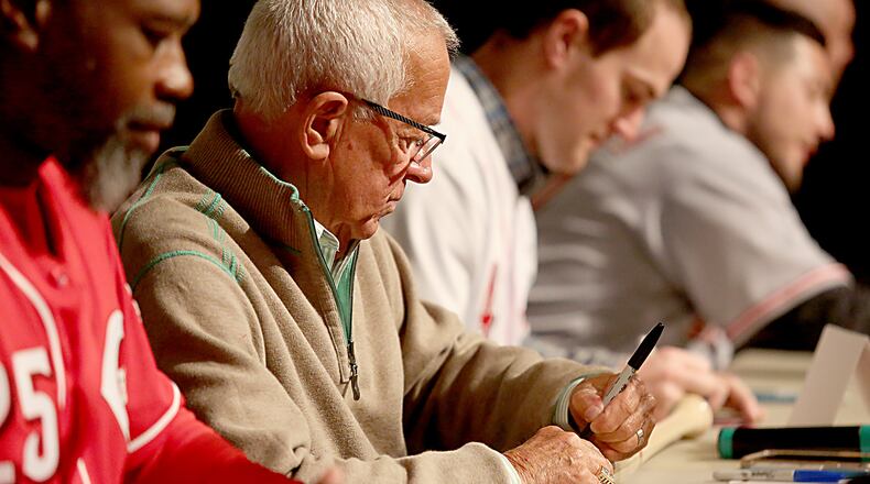 Contributed Photo by E.L. Hubbard
Baseball Hall of Fame announcer Marty Brennaman signs a bat as the Reds Caravan made a stop at Miami University Hamilton campus Staurday, Jan. 28, 2017. Also signing autographs, left to right, Dmitri Young, Brennaman, Scott Schebler, and Blake Trahan.