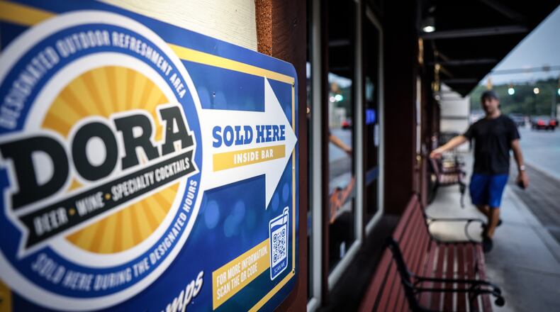 REVISED CUTLINE FOR 122822 mburg dora: Miamisburg launched its Designated Outdoor Refreshment Area, or DORA, in July 2021 with hours of 4 to 9 p.m. Thursdays, 4 to 11 p.m. Fridays, noon to 11 p.m. Saturdays and 4 to 9 p.m. Sundays. Now liquor license holders are asking that the area's hours be extended to 11 a.m. to 11 p.m. Monday through Sunday. STAFF FILE PHOTO (ORIGINAL CAPTION : Miamisburg is working to form an oversight board for its newly formed DORA. Many businesses on Main St. are participating. Jim Noelker/Staff)