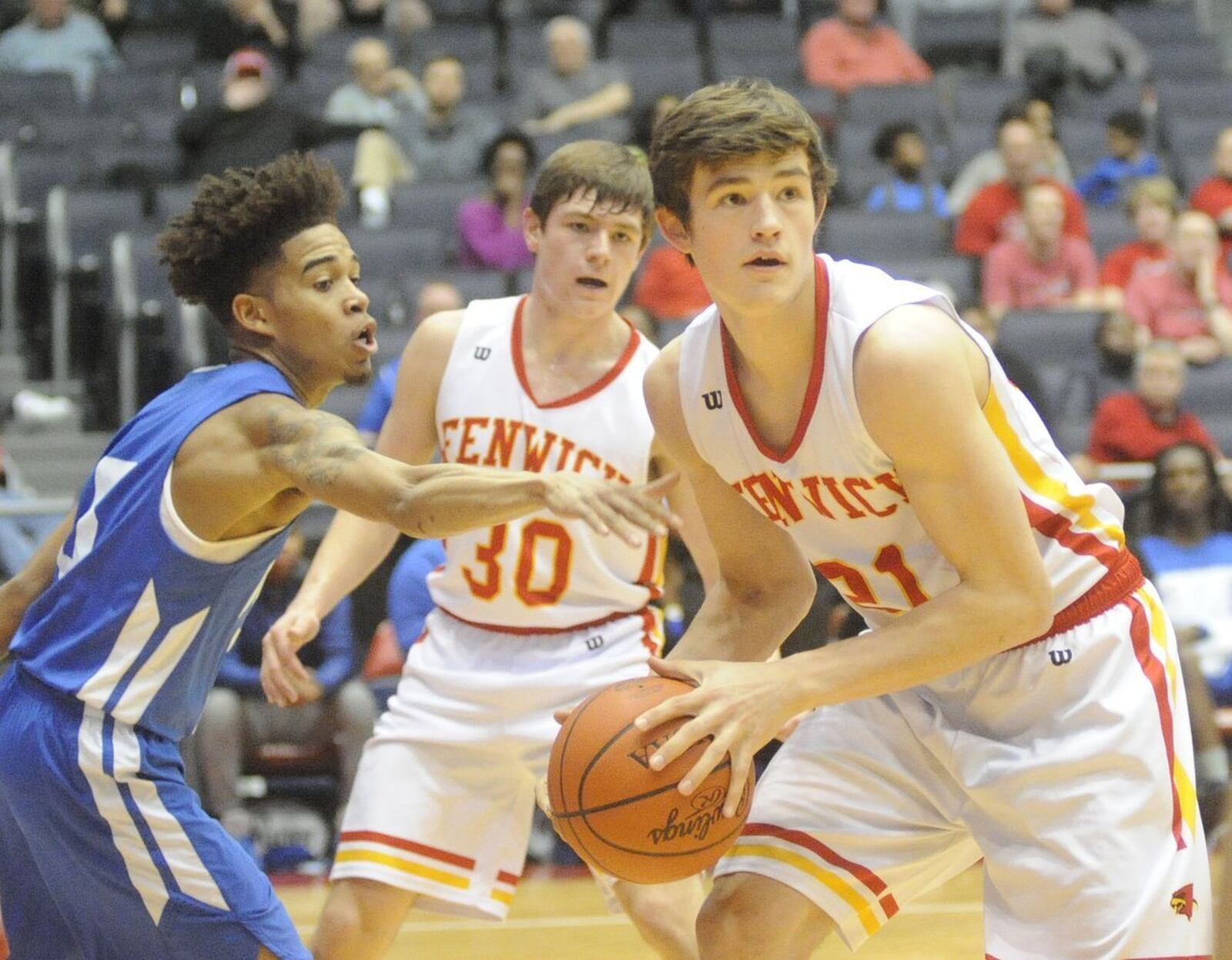 Dunbar’s Kadar Gardner (5) tries to strip the ball away from Fenwick’s Jonathan Hoerlein (21) as his Falcon teammate John Engelmeier (30) looks on during Wednesday night’s Division II sectional final at the University of Dayton Arena. MARC PENDLETON/STAFF
