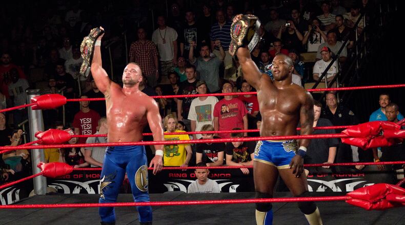 Shelton Benjamin (right) holds the Ring of Honor tag team titles alongside teammate Charlie Haas. Benjamin, now working for WWE, posted a tweet Wednesday after finding a loaded pistol in his rental car. Contributing photo