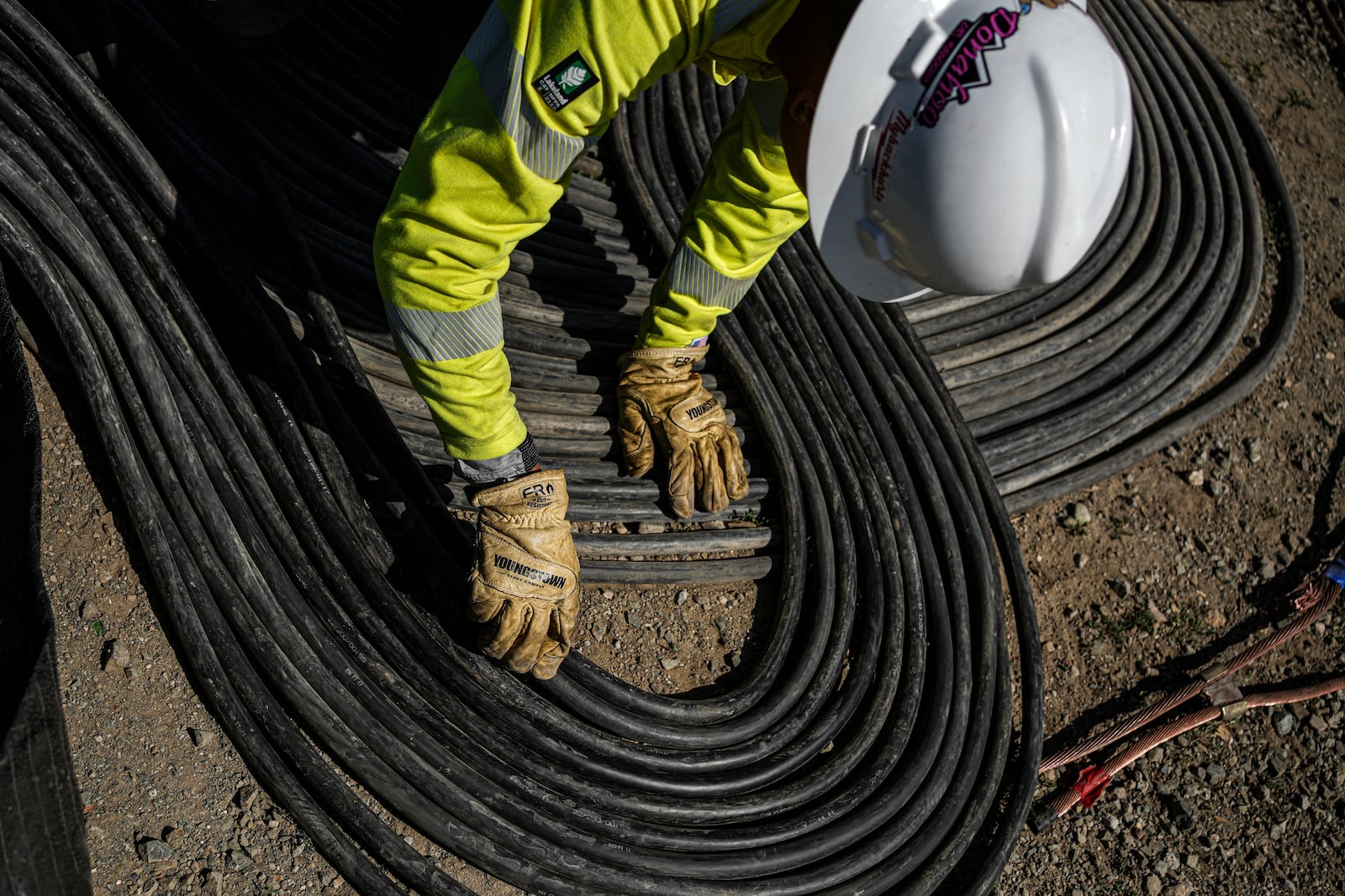 A worker lays cables at Energy Vault, a company that is creating an emergency power system that relies on hydrogen and battery storage, on Tuesday, May 27, 2025, in Calistoga, Calif. (AP Photo/Annika Hammerschlag)