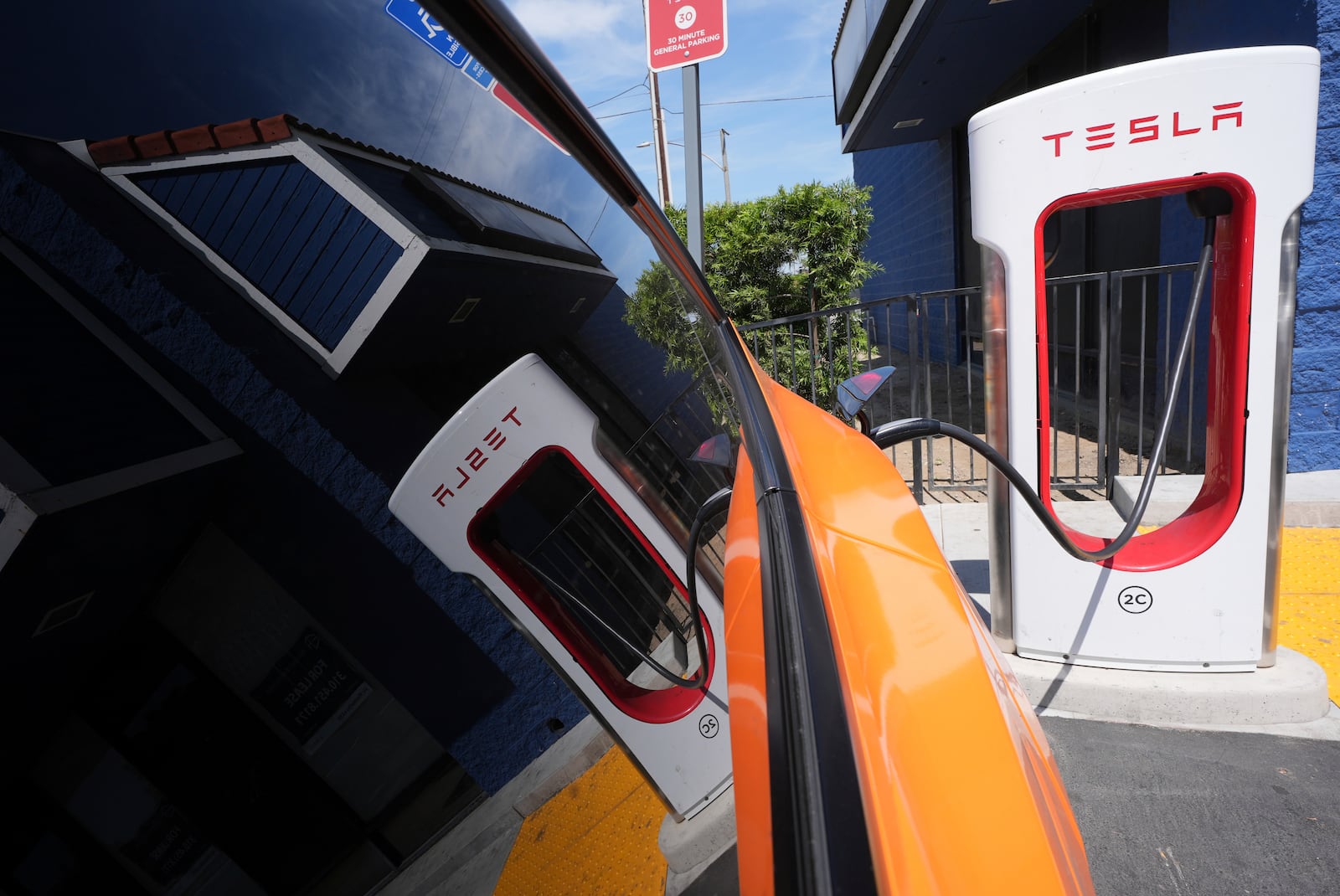 An electric vehicle is seen charging at a charging station Thursday, May 22, 2025, in Long Beach, Calif. (AP Photo/Damian Dovarganes)