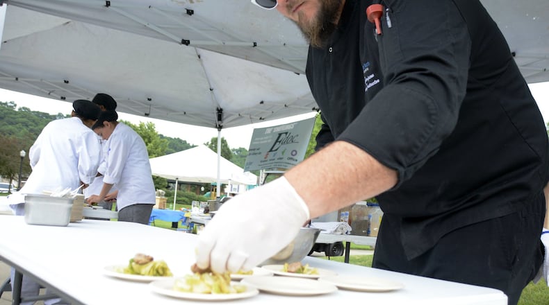 Chef Tyler Simpson, the instructor at Butler Tech culinary program at D. Russel Lee, brings rising seniors to the Village Green Farmers Market in Fairfield once a month to prepare items purchased that day at the market. Samples of the food are given away to patrons at the market. They were at the June 19 market preparing various dishes. MICHAEL D. PITMAN/STAFF