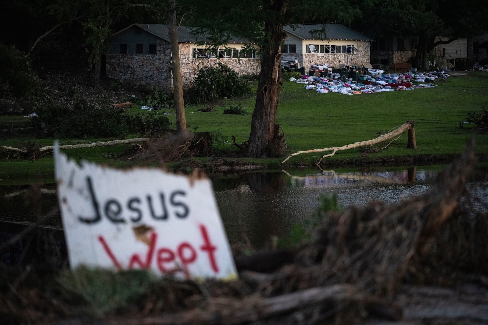 Camper's belongings sit outside one of Camp Mystic's cabins near the Guadalupe River after a flash flood swept through the area Monday, July 7, 2025, in Hunt, Texas. (AP Photo/Eli Hartman)