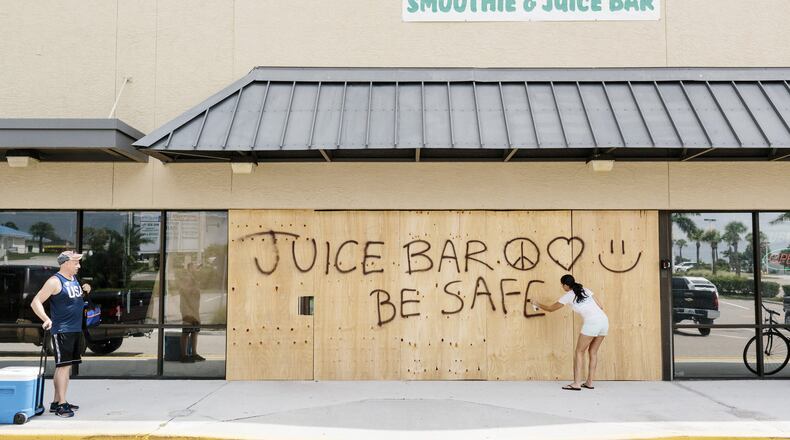 Paige Oldenburg spray paints the wood outside her juice bar in Jensen Beach, Fla., Sept. 8, 2017. The National Hurricane Center said Irma remained “extremely dangerous,” with winds of 150 miles per hour, and the Florida Keys were at risk of “life-threatening inundation.” It is expected to hit the Florida Keys and South Florida by Saturday night. (Jason Henry/The New York Times)