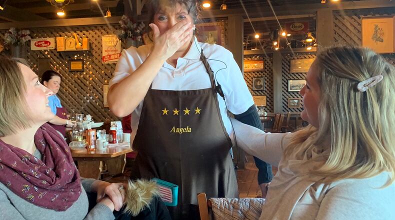 Angela Fuller of West Carrolton, a waitress at Cracker Barrel, was visited by a group of "Breakfast Santas" organized by Monica Deal of Centerville. The group of 11 women left Fuller a $1,000 tip. CONTRIBUTED PHOTO