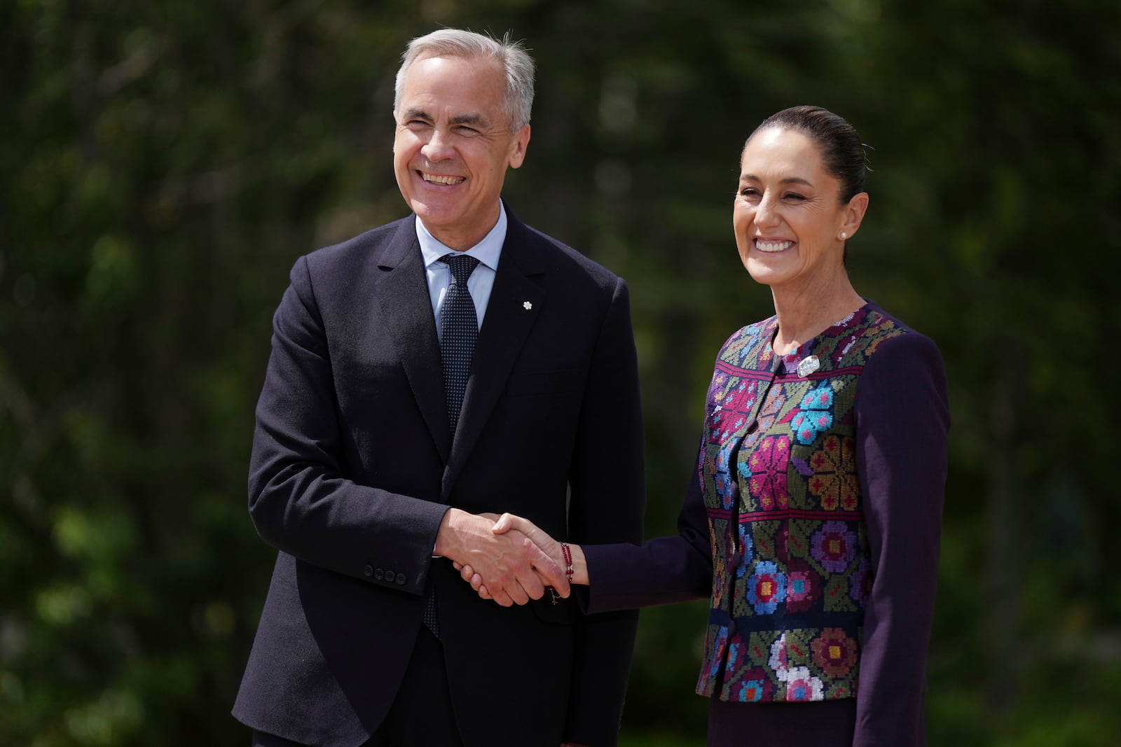 Canada's Prime Minister Mark Carney welcomes Mexican President Claudia Sheinbaum to the G7 Summit in Kananaskis, Alberta, Tuesday, June 17, 2025. (Darryl Dyck/The Canadian Press via AP)