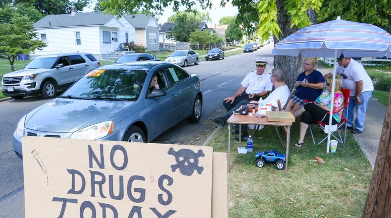 Hamilton Police Chief Craig Bucheit talks with Parkamo Ave. resident Denny Matheny who decided to place a sign outside his house in an effort to curb drug use in the neighborhood. Matheny was joined throughout the day by various neighbors family members. GREG LYNCH / STAFF