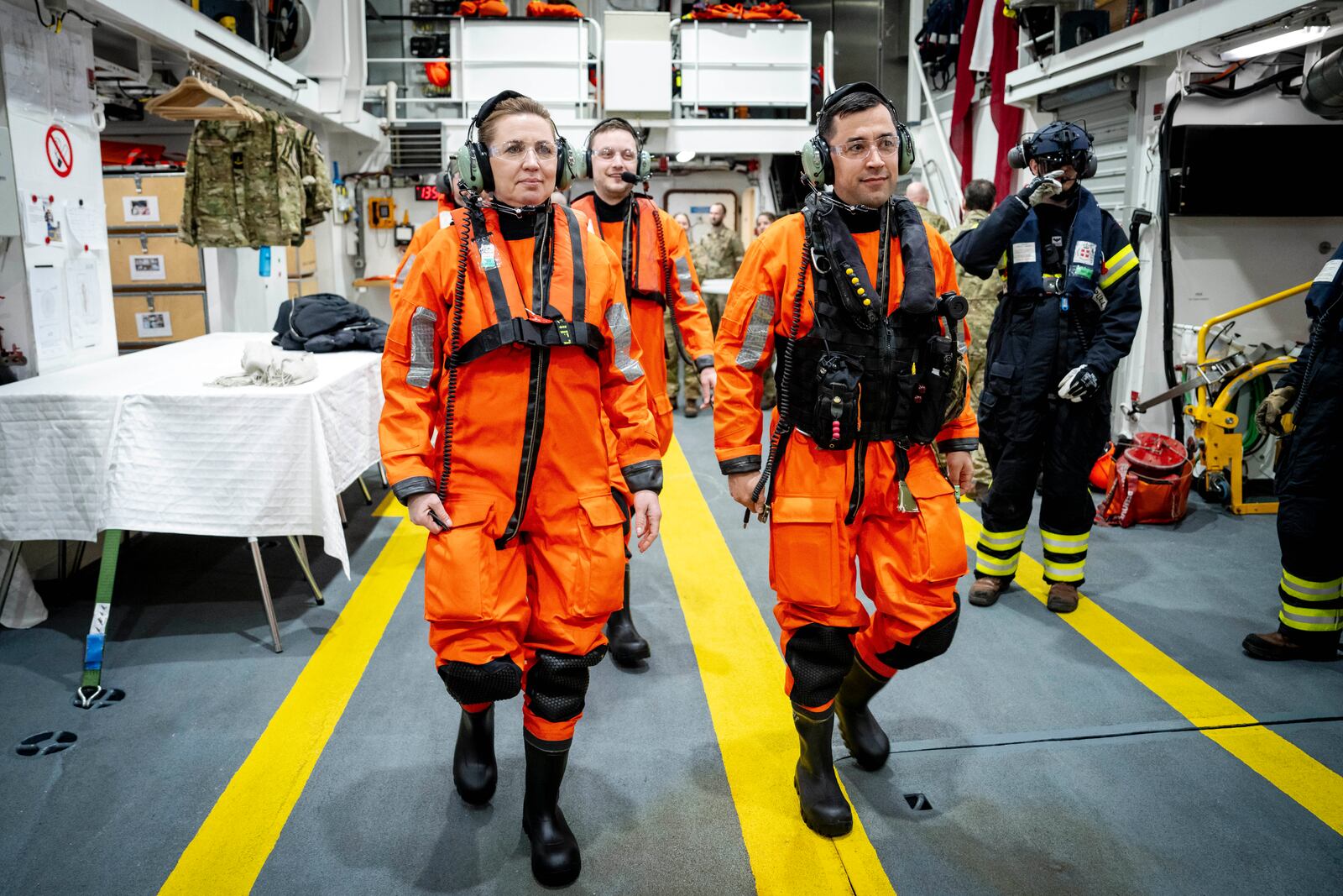 Denmark's Prime Minister Mette Frederiksen, left, Greenlands acting head of government Múte Bourup Egede, right, and newly elected head of government, Jens-Frederik Nielsen, center, prepare to embark on a trip with a Danish Navy Sea Hawk helicopter from the Danish Navy inspection ship Vaedderen, in the waters around Nuuk, Greenland, Thursday, April 3, 2025. (Mads Claus Rasmussen/Ritzau Scanpix via AP)