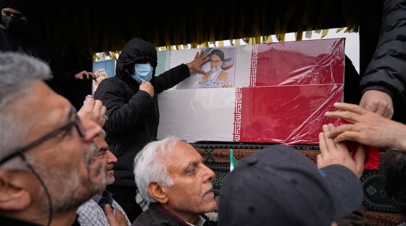 Iranians reach toward the coffins as they follow the funeral procession of Iran's intelligence minister Esmail Khatib and, according to Iranian officials, his wife and daughter, in Tehran, Iran, Friday, March 20, 2026. (AP Photo/Vahid Salemi)