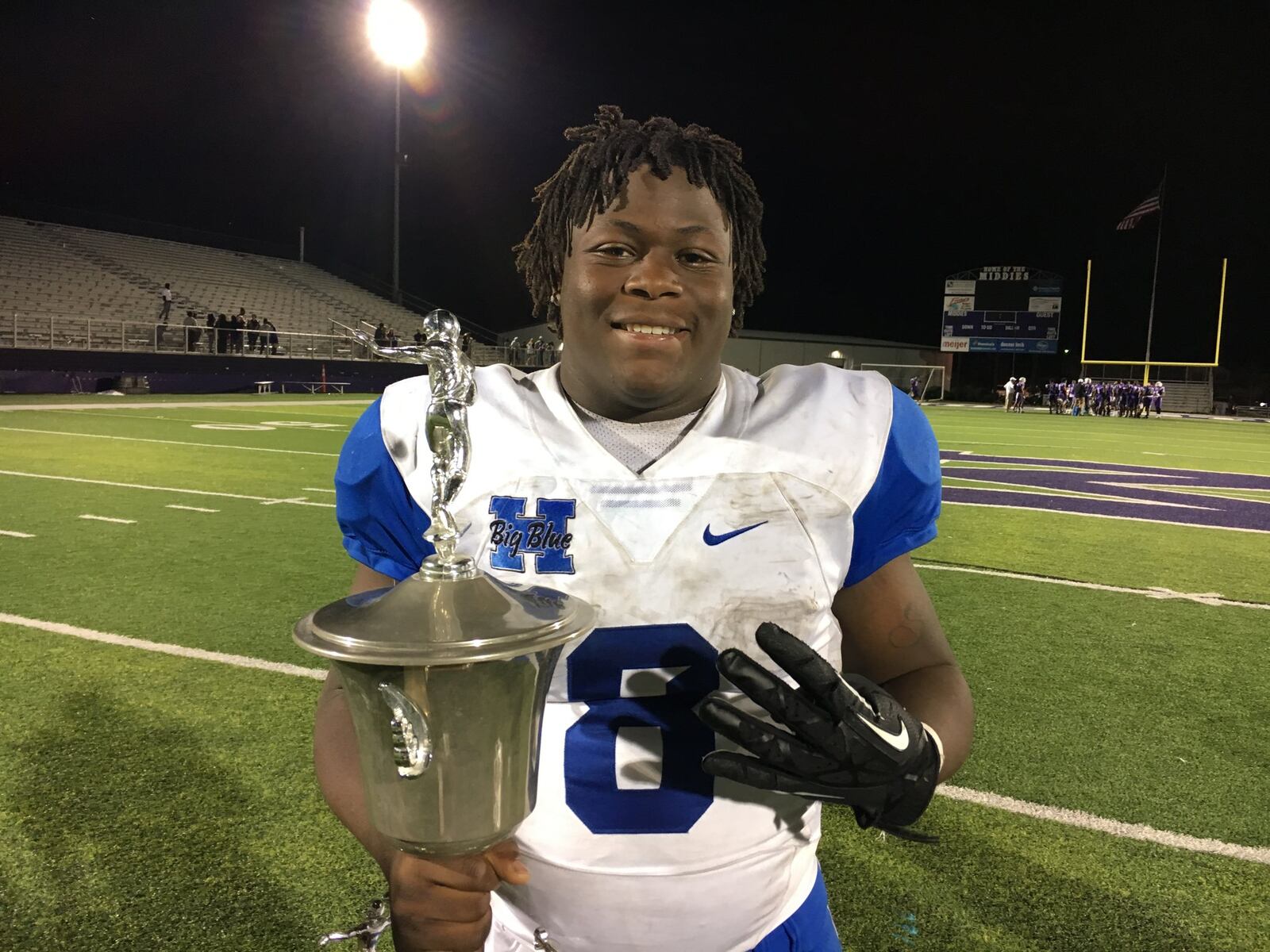 Hamilton’s Maleek Jarrett poses with the Butler Bowl trophy Friday night after rushing for four touchdowns in Big Blue’s 47-26 victory over Middletown at Barnitz Stadium in Middletown. RICK CASSANO/STAFF