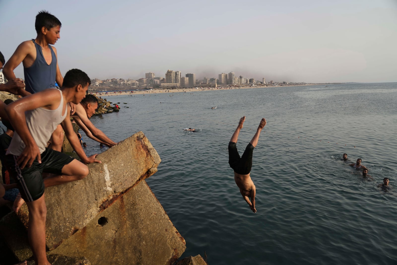 Palestinians jump into the water of the Mediterranean Sea to cool down during a heat wave in Gaza City, Saturday, May 17, 2025. (AP Photo/Jehad Alshrafi)