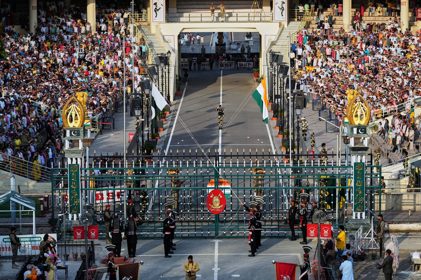 Pakistan's Rangers soldiers, in black, and Indian Border Security Forces soldiers, behind the gate, lower their flags during a daily closing ceremony at the Wagah, a joint post on the Pakistan and India border, near Lahore, Pakistan, Monday, May 5, 2025. (AP Photo/K.M. Chaudary)