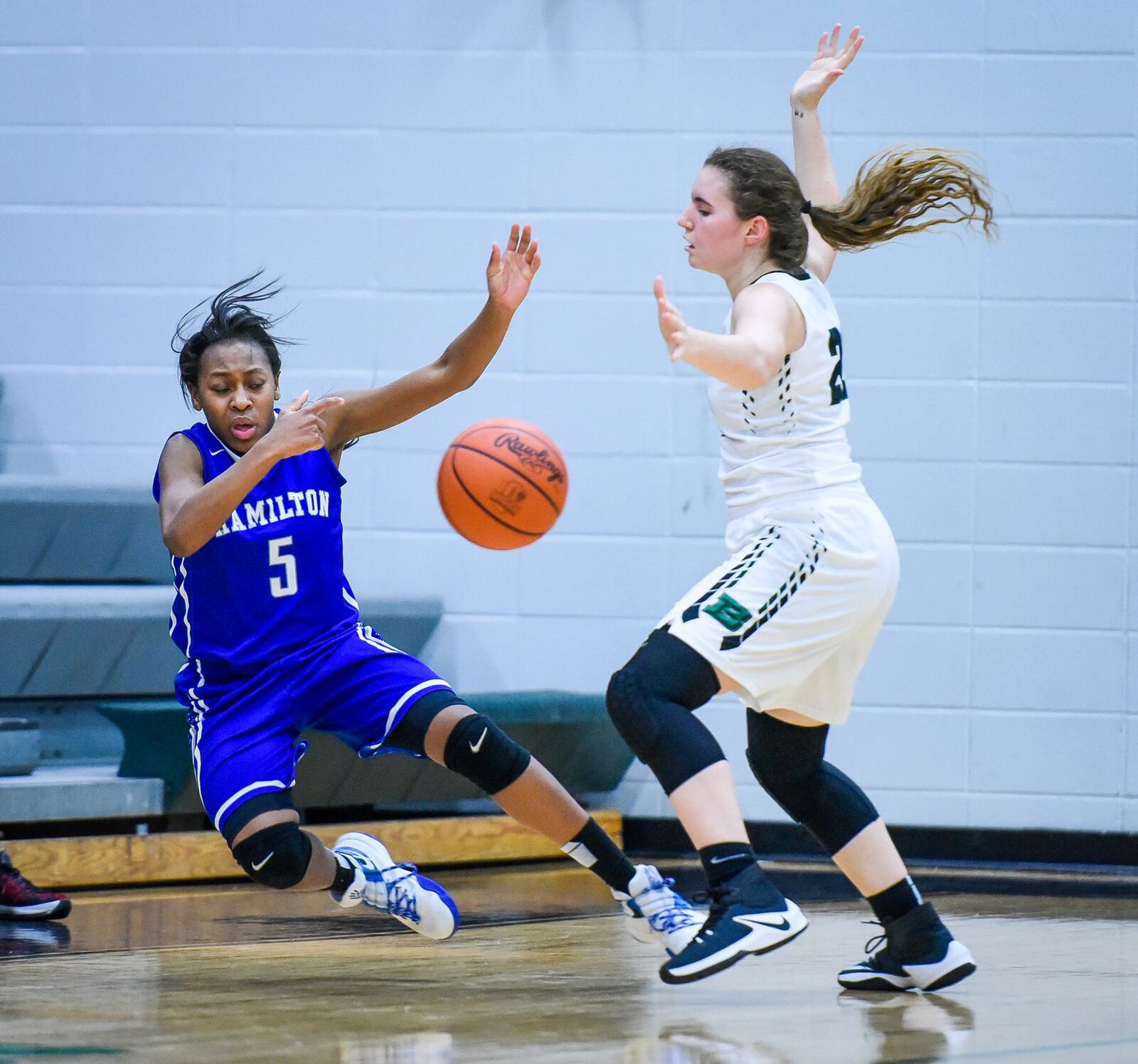 Hamilton’s Anna Cardwell gets knocked down by Badin’s Lauren Krause during Monday night’s game at Mulcahey Gym in Hamilton. NICK GRAHAM/STAFF