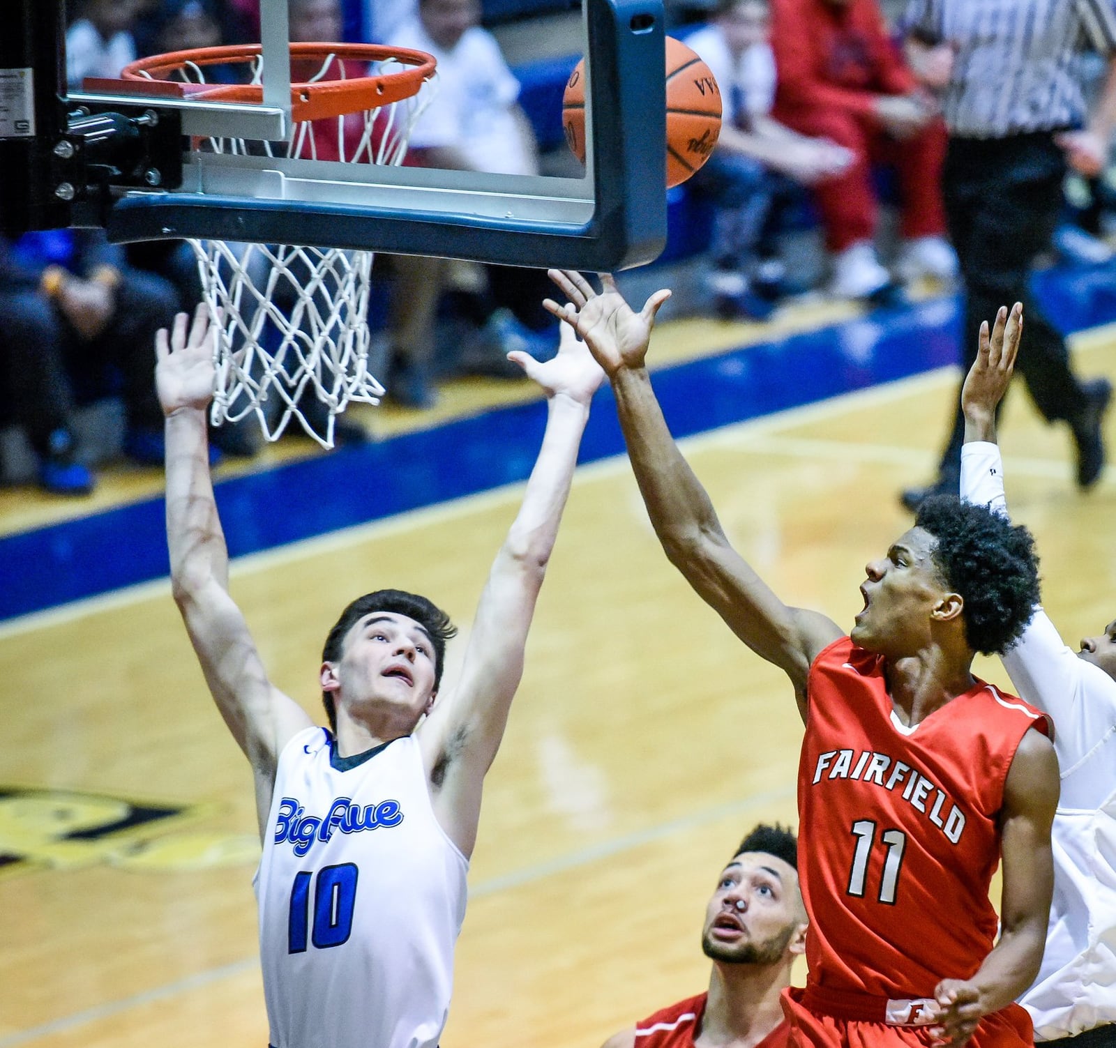 Fairfield’s Andre Givens puts up a shot while being defended by Hamilton’s Daniel Brunck during Tuesday night’s game at the Hamilton Athletic Center. NICK GRAHAM/STAFF