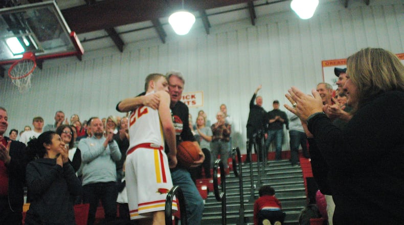 Fenwick’s C.J. Napier hugs his father Eric after scoring the 1,000th point of his career during Saturday night’s 58-53 victory over visiting St. Xavier in Middletown. RICK CASSANO/STAFF