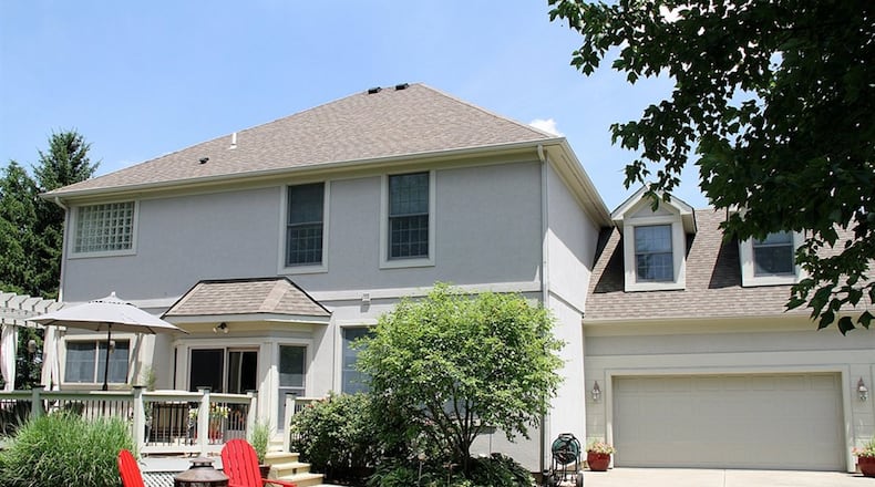 Patio doors off the bay bump-out open to a composite deck with pergola and a tree-lined back yard. The driveway that leads to the 3-car garage has a sun patio extension. A bonus room is above the garage, and the 2-story has a finished basement.