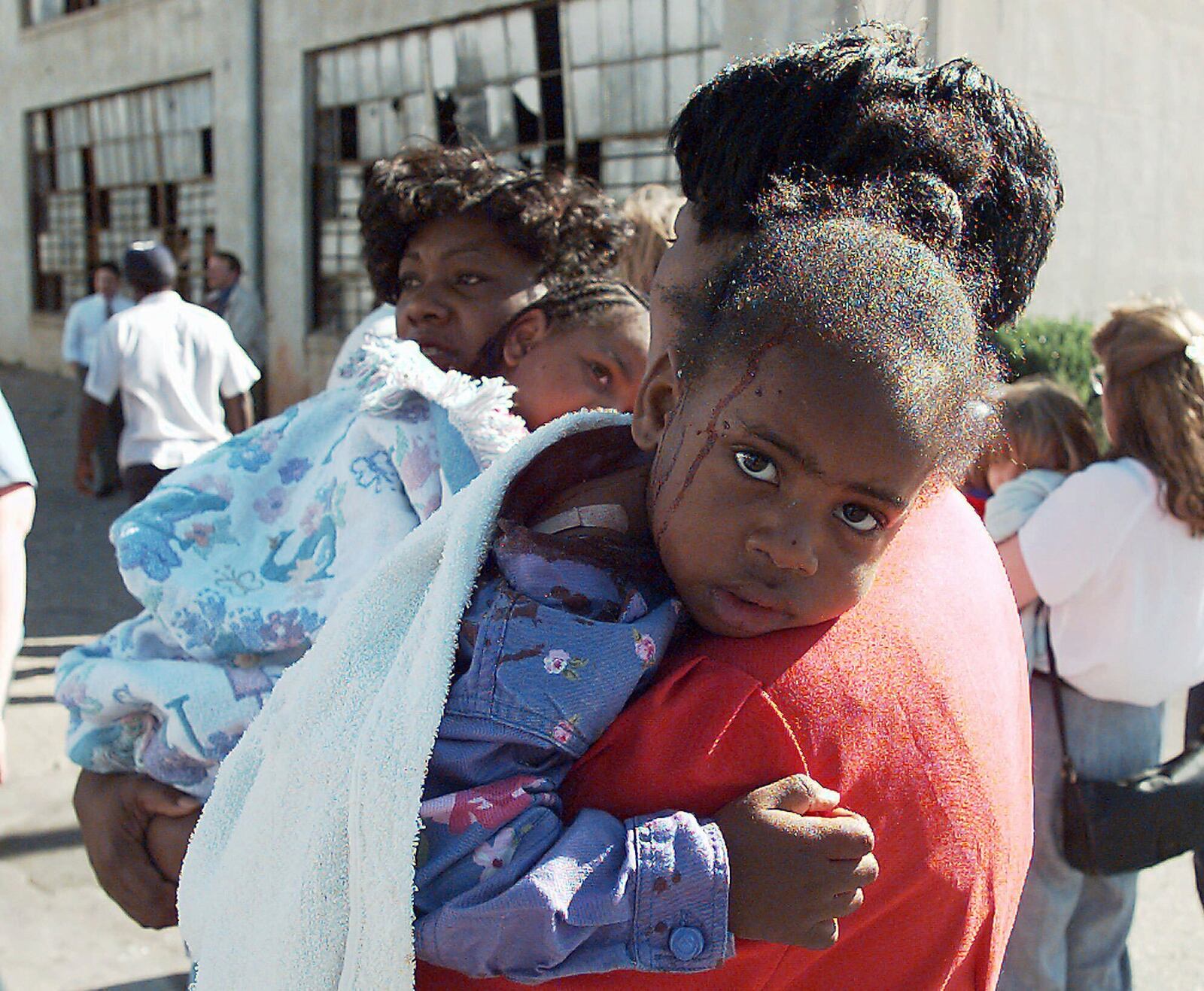 FILE - A woman comforts an injured child following an explosion at the Alfred P. Murrah Federal Building in Oklahoma City on April 19, 1995. (AP Photo/David Longstreath, File)