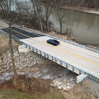A car travels over the Franklin-Trenton Road bridge Dec. 30, 2025, in Franklin Twp., just days after it opened. A portion of the old bridge collapsed over Dry Run on Feb. 27, 2025, roughly 10 months earlier. NICK GRAHAM/STAFF