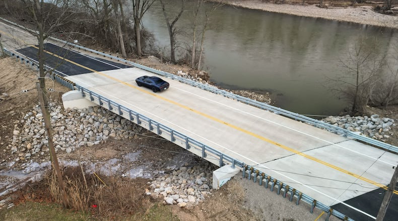 A car travels over the Franklin-Trenton Road bridge Dec. 30, 2025, in Franklin Twp., just days after it opened. A portion of the old bridge collapsed over Dry Run on Feb. 27, 2025, roughly 10 months earlier. NICK GRAHAM/STAFF