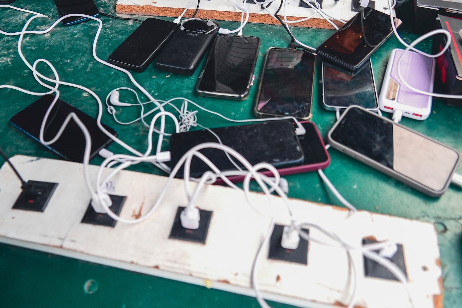 Phones are kept for charging at a Doctors Without Borders informal camp in Mardyck, northern France, Wednesday, July 2, 2025. (AP Photo/Nicolas Garriga)