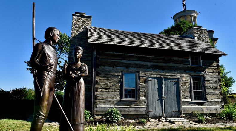 A historic log cabin dating to 1802 sits next to the Sailors, Soldiers and Pioneers monument in Hamilton. NICK GRAHAM / STAFF