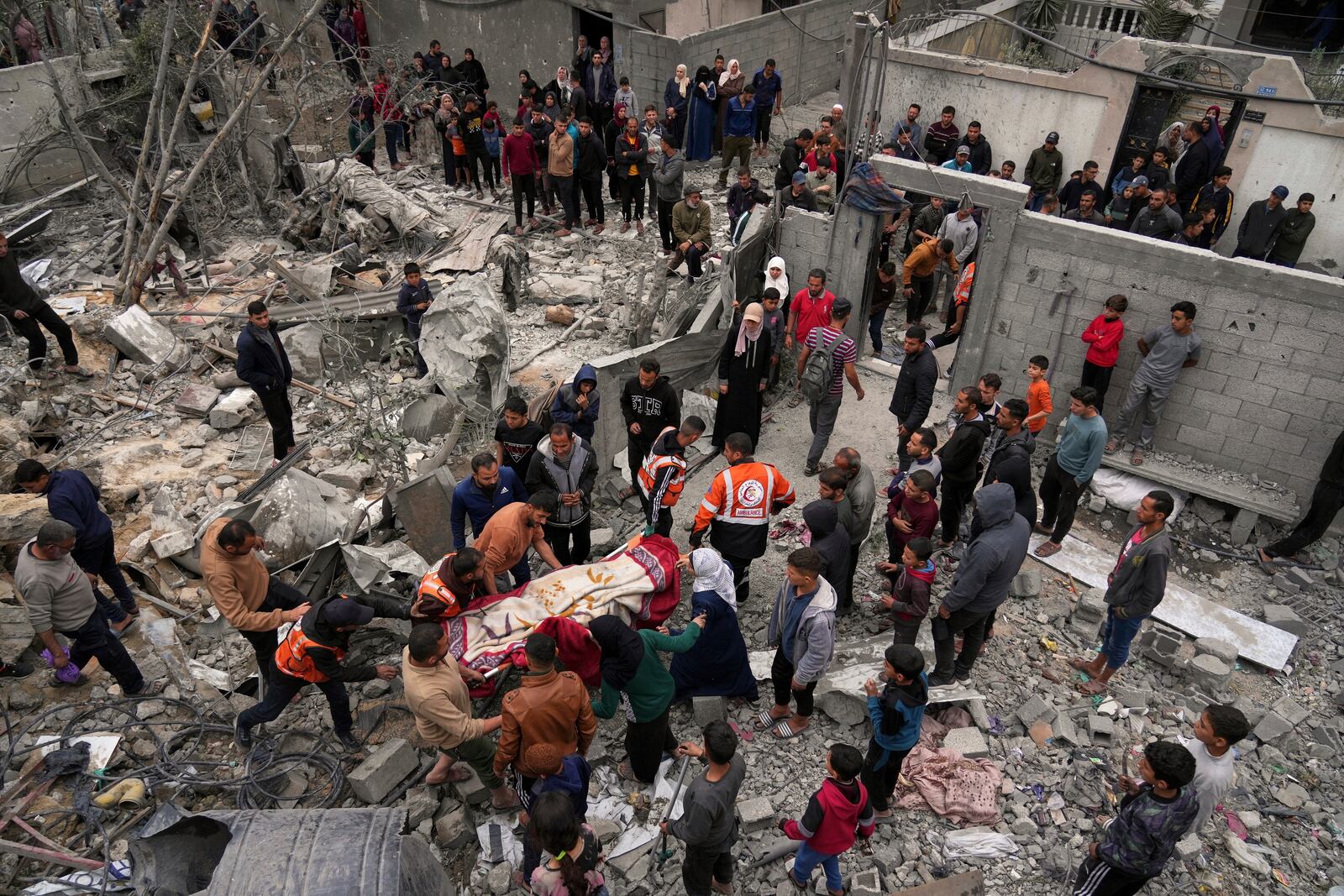 Volunteers and emergency workers remove a body from the rubble of the Manoun family's house after it was targeted by an Israeli army strike in Jabalia al-Balad, Gaza City, Sunday, April 13, 2025. (AP Photo/Jehad Alshrafi)