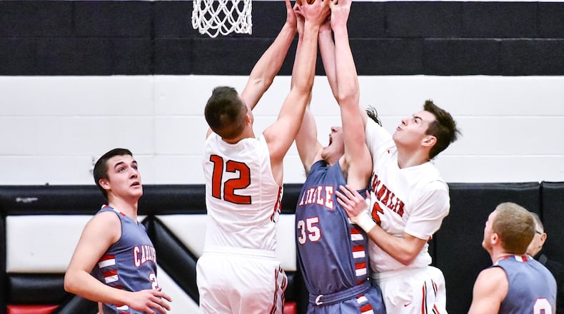 Carlisle’s Johnathan Shepherd (35) battles for a rebound with Franklin’s Braden Hall (12) and Cole Bundren (5) during Tuesday night’s game at Darrell Hedric Gym in Franklin. NICK GRAHAM/STAFF