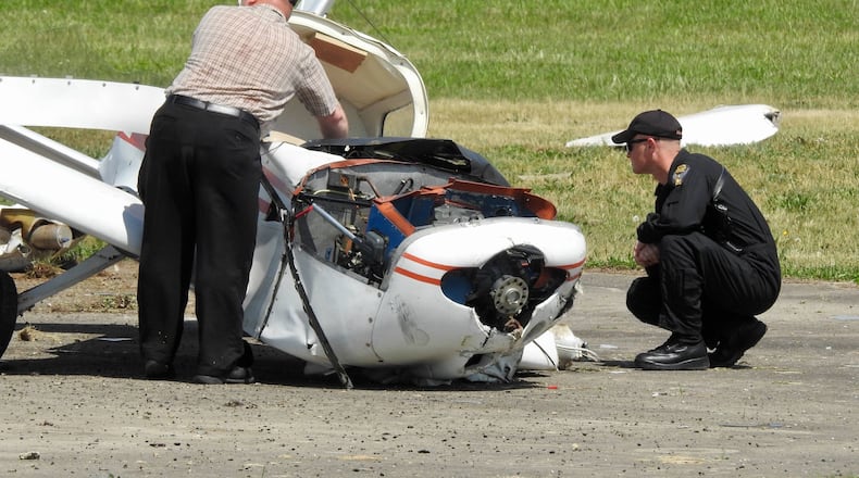 Emergency crews and investigators look over an airplane that crashed at Butler County Regional Airport, Tuesday, May 15. Henry Rosche III, 63, of Loveland, was injured in the crash when his 1974 Grumman plane experienced engine failure, according to the Ohio Highway Patrol. NICK GRAHAM/STAFF