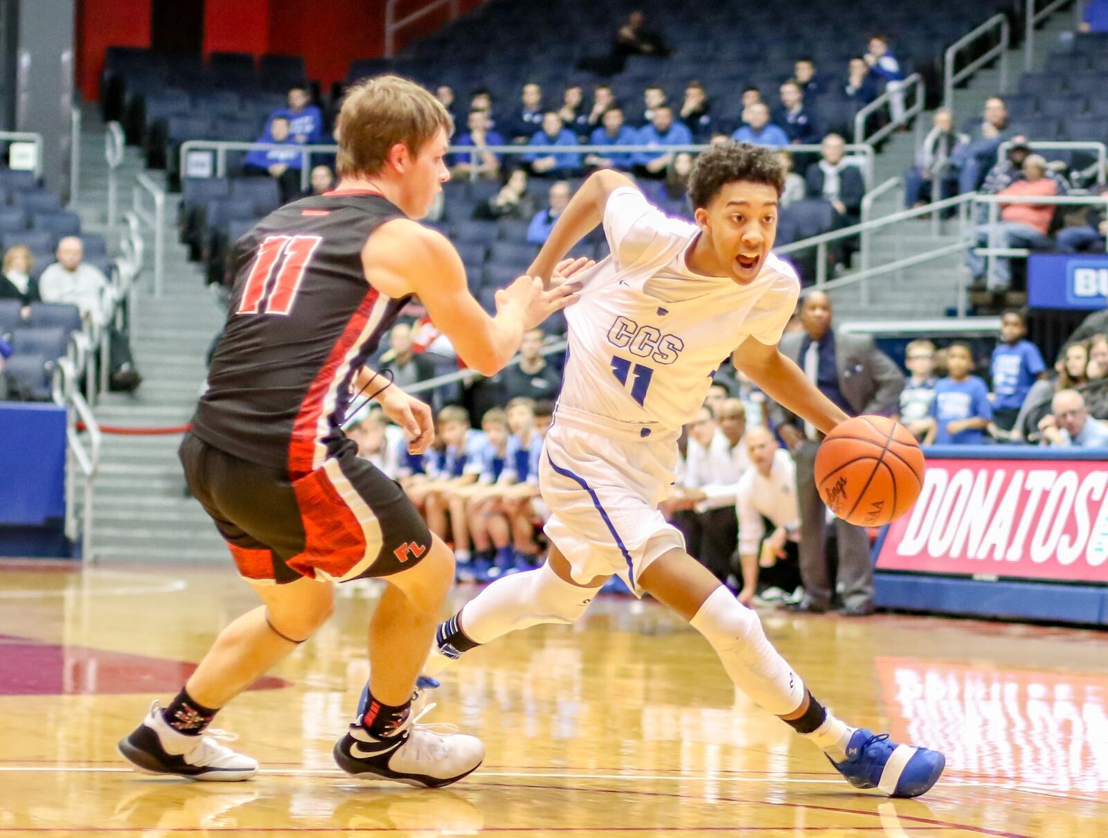 Cincinnati Christian’s Logan Woods tries to dribble past Fort Loramie’s Nick Brandewie (11, black jersey) during Friday night’s Division IV district basketball final at the University of Dayton Arena. Fort Loramie won 49-41. CONTRIBUTED PHOTO BY MICHAEL COOPER