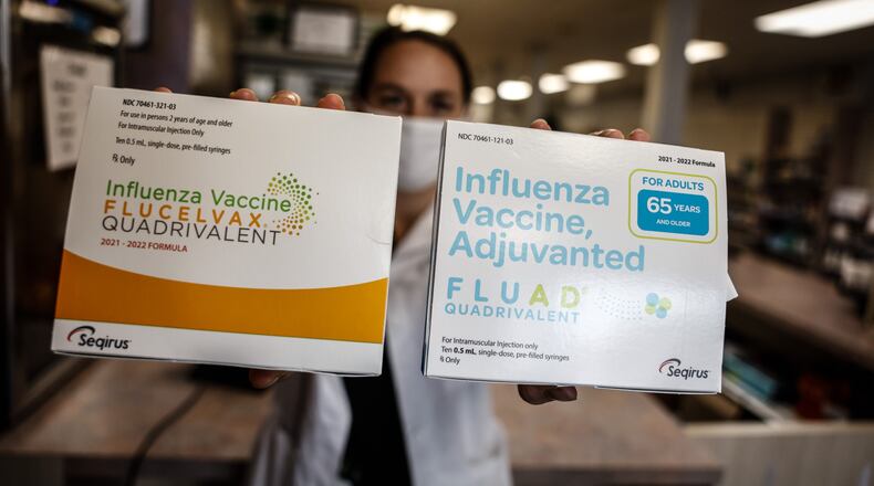 Germantown Pharmacy pharmacist, Katie Perry holds up two different flu shot that are available. The 2021–22 influenza season is expected to coincide with continued circulation of SARS-CoV-2, the virus that causes COVID-19. JIM NOELKER/STAFF