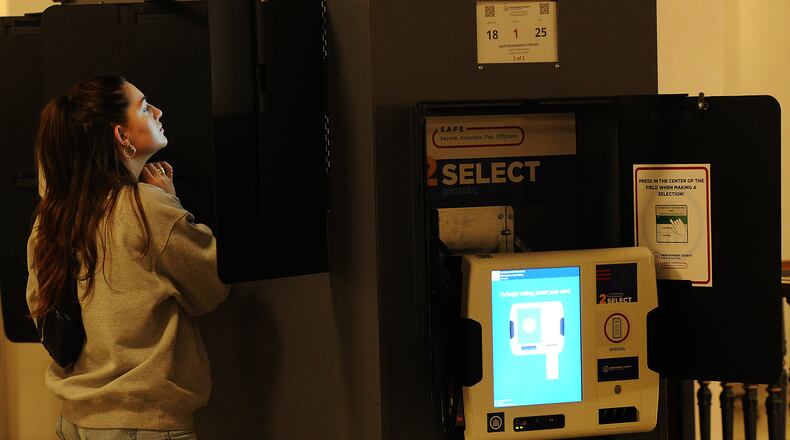 Lorelei Fink reads over her ballot while voting Tuesday Nov. 8, 2022 at the Dayton Masonic Temple. MARSHALL GORBY\STAFF