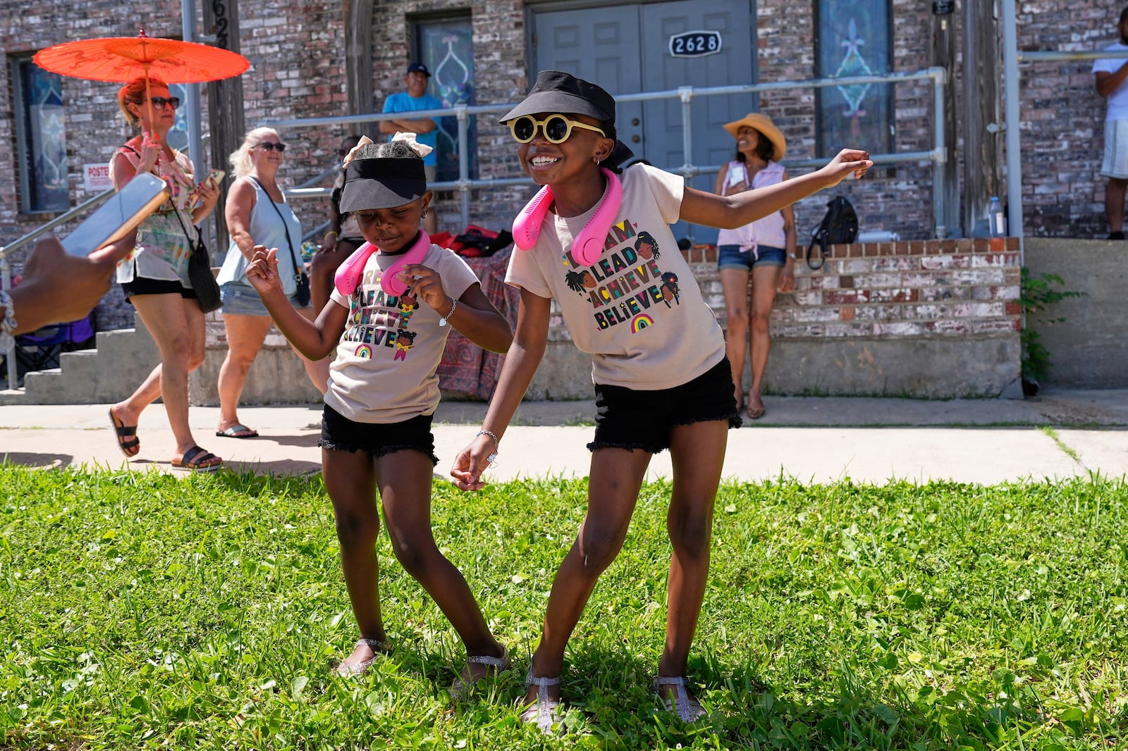 Kelsea and Kennedy Branford watch during a Juneteenth parade Thursday, June 19, 2025, in Galveston, Texas. (AP Photo/David J. Phillip)