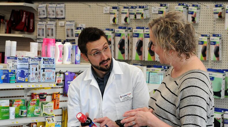 Cedar Care Village Pharmacy Pharmacist Dr. Justin Coby talks with Lea Ann Anspach. Coby said some manufacturers are not going to comply with new price negotiations under Medicare, which could mean patients having to switch to different medications or pay out of pocket. MARSHALL GORBY\STAFF