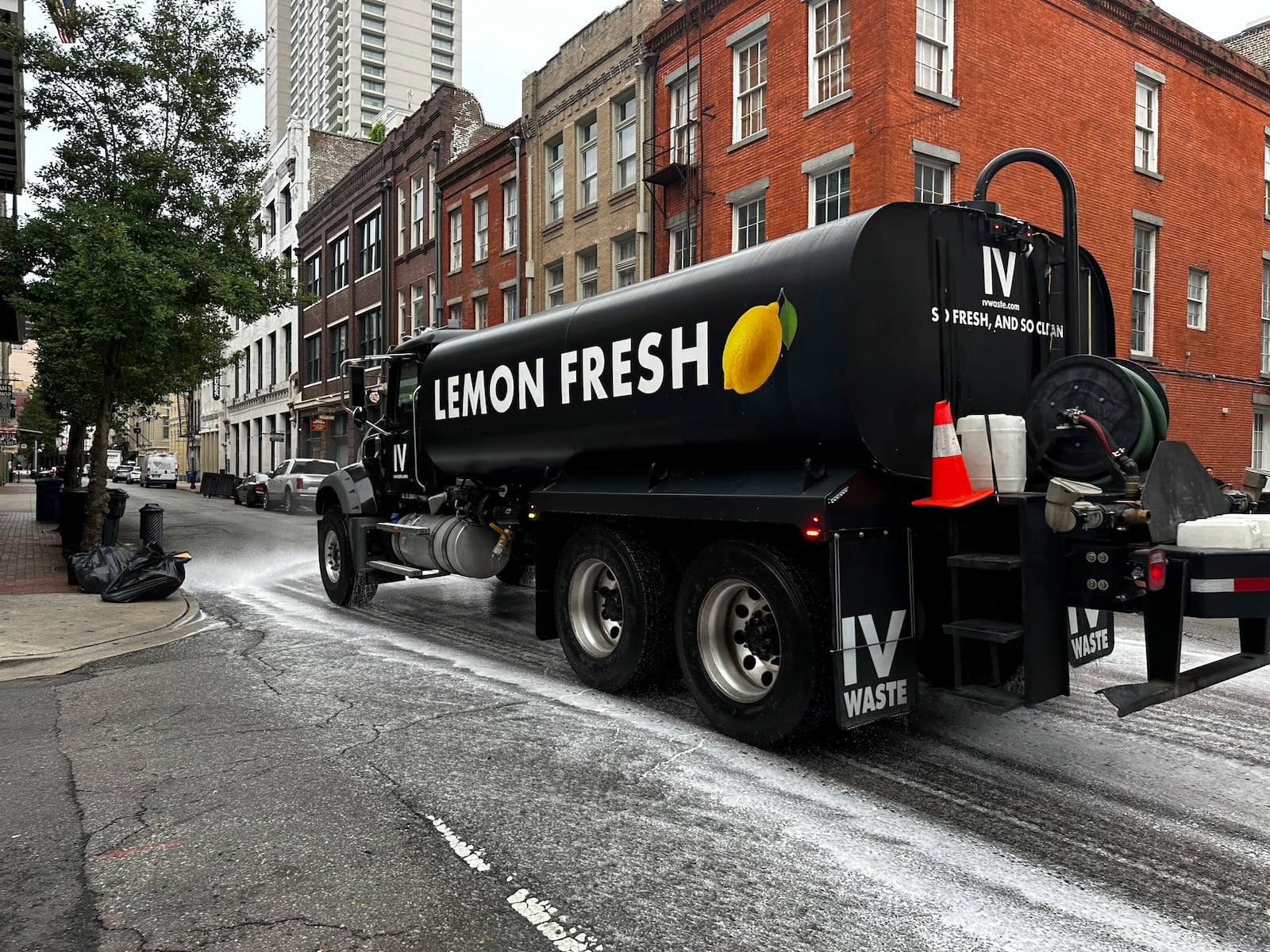 A sanitation truck spraying lemon scented soap rolls down Decatur Street in the French Quarter leaving behind a trail of suds, Wednesday, July 23, 2025, in New Orleans. (AP Photo/Stephen Smith)