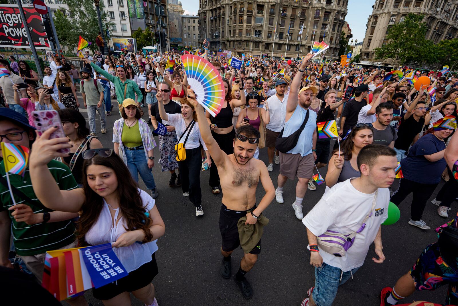 People dance while holding rainbow flags during the Bucharest Pride Parade, in Bucharest, Romania, Saturday, June 7, 2025. (AP Photo/Andreea Alexandru)