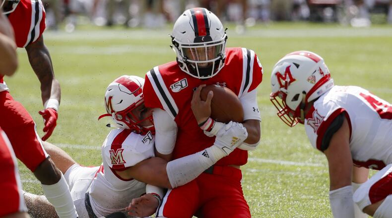Cincinnati quarterback Desmond Ridder, center, is tackled on the run by Miami of Ohio defensive back Sterling Weatherford, center left, in the first half of an NCAA college football game, Saturday, Sept. 14, 2019, in Cincinnati. (AP Photo/John Minchillo)