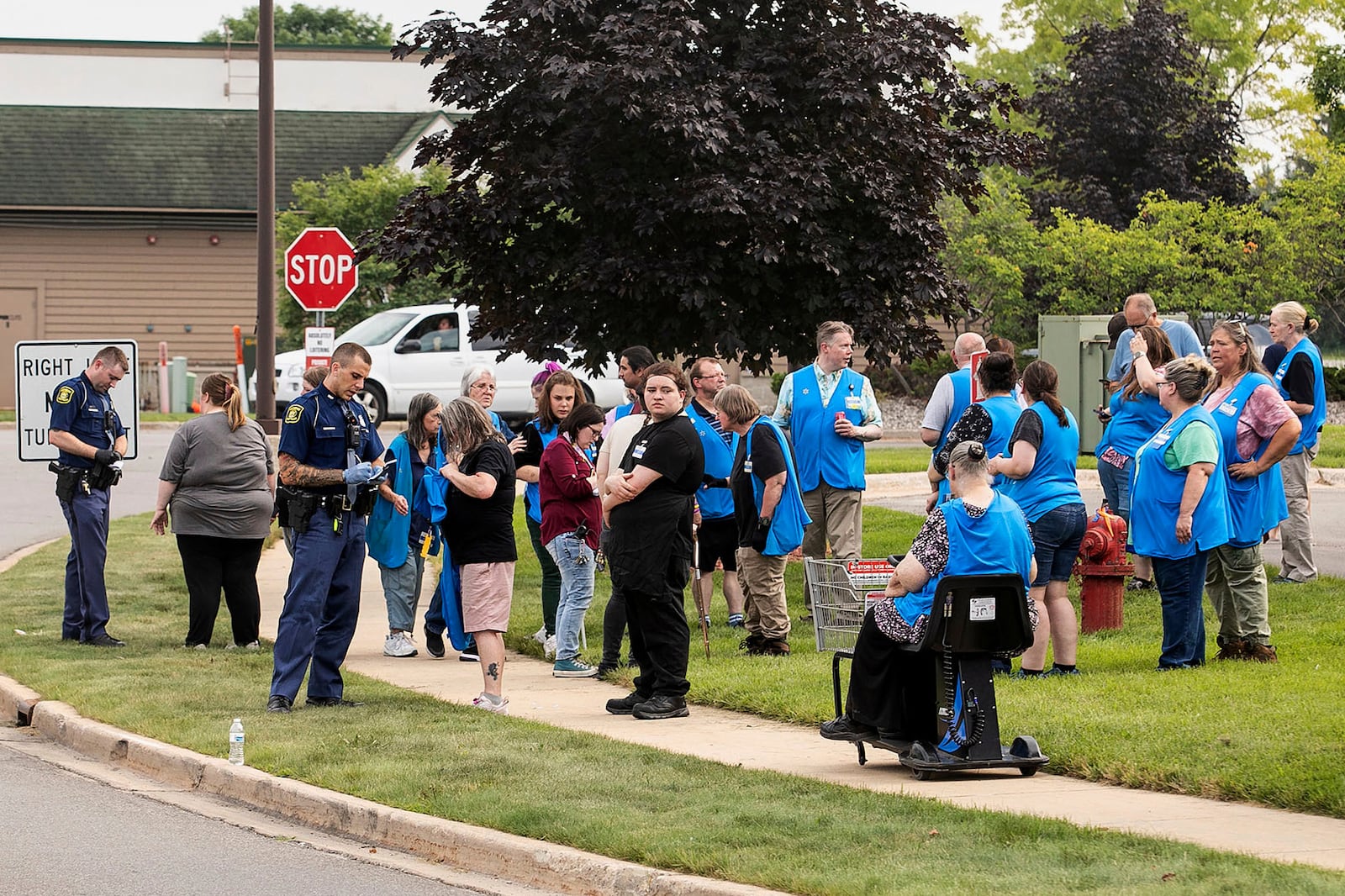 Michigan State Police officers talk to employees near the scene after a stabbing incident at a Walmart in Traverse City, Mich., Saturday July 26, 2025. (Jan-Michael Stump/Traverse City Record-Eagle via AP)