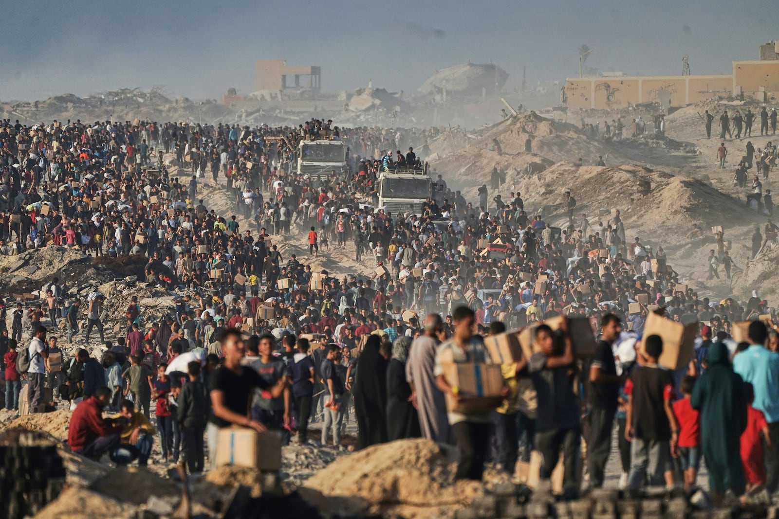 FILE - Palestinians carry sacks and boxes of food and humanitarian aid, unloaded from a World Food Program convoy that was heading to Gaza City in the northern Gaza Strip, Monday, June 16, 2025. (AP Photo/Jehad Alshrafi, file)
