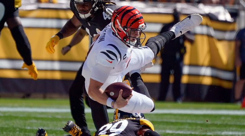 Cincinnati Bengals quarterback Joe Burrow (9) tumbles over Pittsburgh Steelers free safety Minkah Fitzpatrick (39) after scrambling for a first down during the first half an NFL football game, Sunday, Sept. 26, 2021, in Pittsburgh. (AP Photo/Gene J. Puskar)