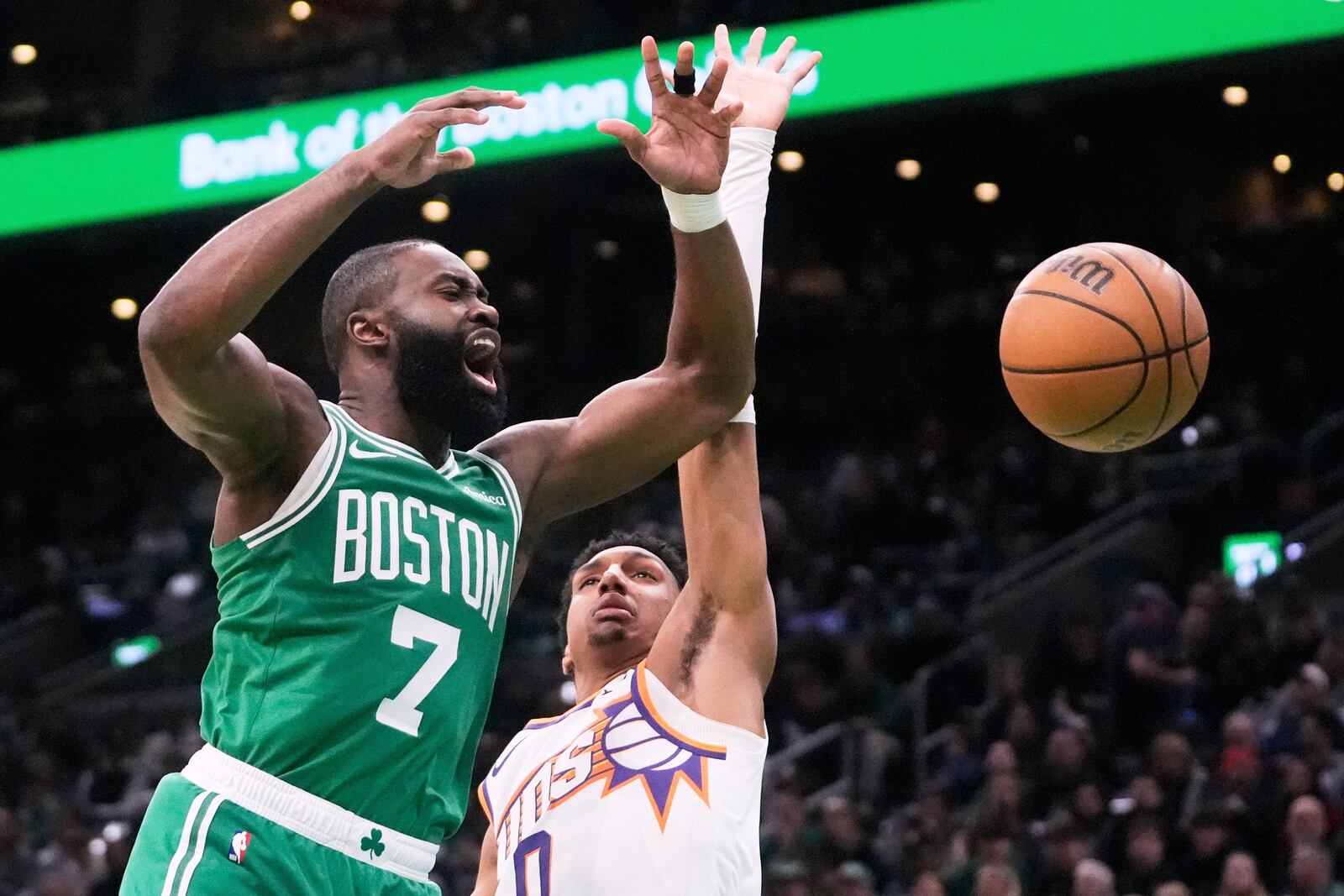 Boston Celtics guard Jaylen Brown (7) loses control of the ball against Phoenix Suns forward Ryan Dunn (0) during the first half of an NBA basketball game, Friday, April 4, 2025, in Boston. (AP Photo/Charles Krupa)